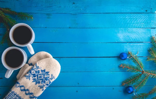 Cups of coffee with mittens on wooden background. — Stock Photo, Image