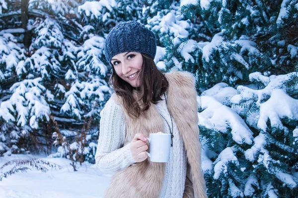 Mujer sostiene taza de café con malvavisco en el bosque de invierno — Foto de Stock