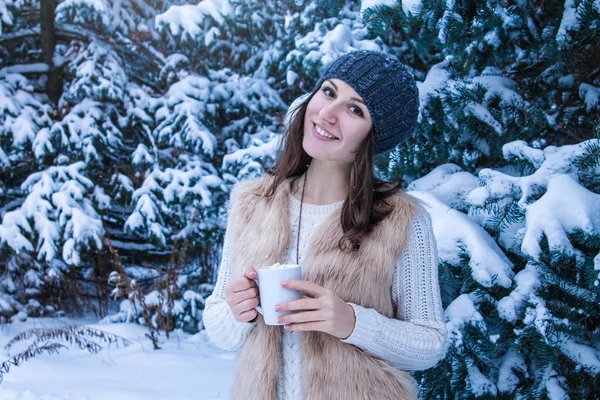 Mujer sostiene taza de café con malvavisco en el bosque de invierno — Foto de Stock