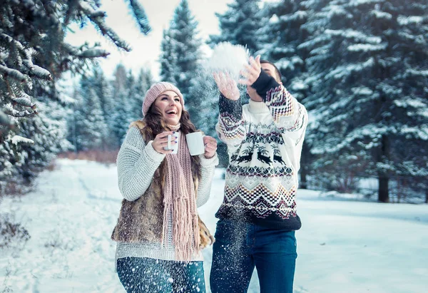 Casal jogando neve na floresta de inverno — Fotografia de Stock