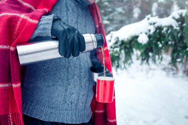 Adam ormandaki termos sıcak çay dökülen