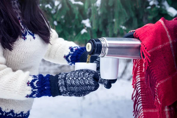 Genç çift ormanda termos sıcak çay dökülen