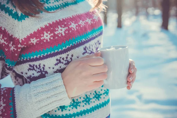 Woman holds cup of coffee with marshmallow in winter forest — Stock Photo, Image