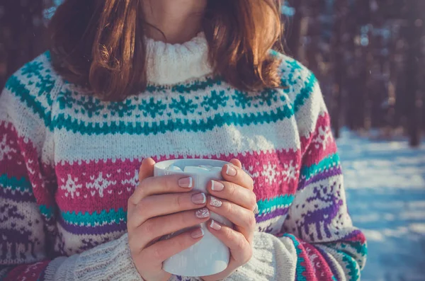 Kvinna håller kopp kaffe med marshmallow i vinter skog — Stockfoto