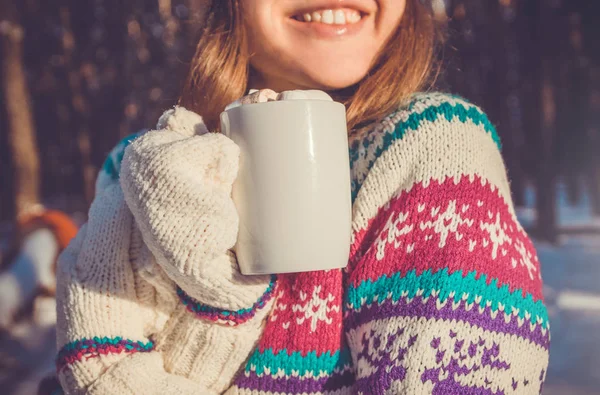 Kvinna håller kopp kaffe med marshmallow i vinter skog — Stockfoto