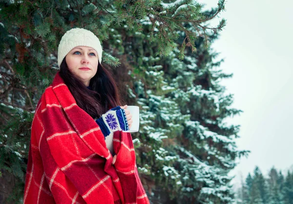 Donna tiene una tazza di caffè nella foresta invernale — Foto Stock