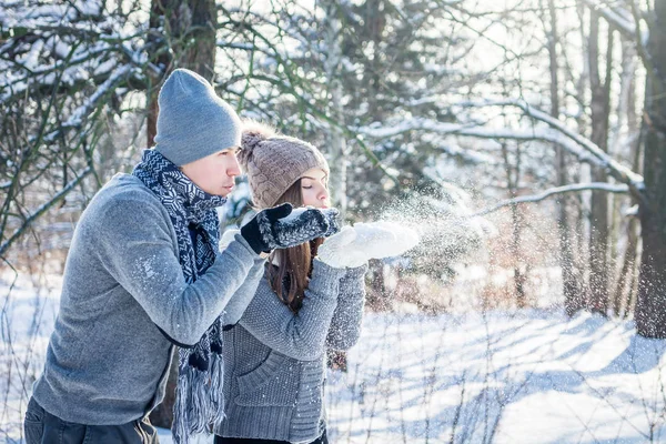 Giovane coppia innamorata soffia neve — Foto Stock