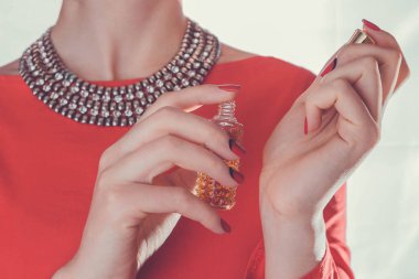 Kadın bileğine parfüm sürüyor.