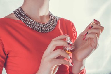 Kadın bileğine parfüm sürüyor.