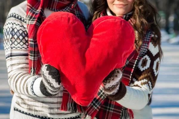 Casal segura coração travesseiro vermelho — Fotografia de Stock
