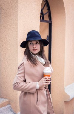 Kadın bir fincan kahve tutuyor.