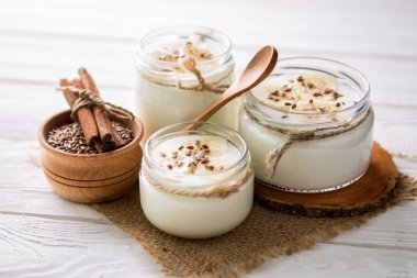 Ahşap arka plan üzerinde cam kavanozlara yoğurt