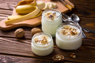 Ahşap arka plan üzerinde cam kavanozlara yoğurt