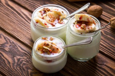 Ahşap arka plan üzerinde cam kavanozlara yoğurt