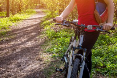 Ormanda bisiklet süren genç bir kadın.
