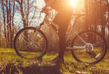 Ormanda bisiklet süren genç bir kadın.