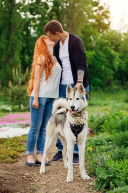 genç bir çift bir köpek parkta yürüyüş