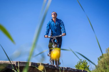 Genç bisikletçi gökyüzüne karşı