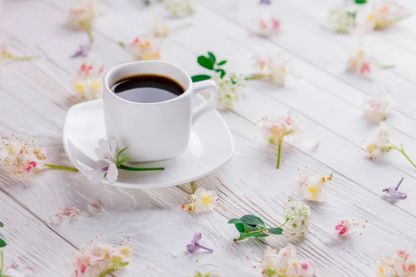Чашка кофе в окружении цветов — стоковое фото