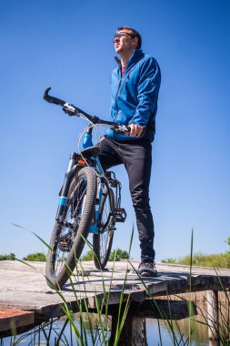 Genç bisikletçi köprüde rides