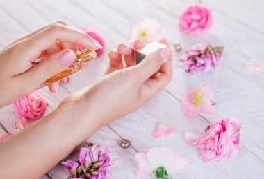 Kadın bileğine parfüm sürüyor.