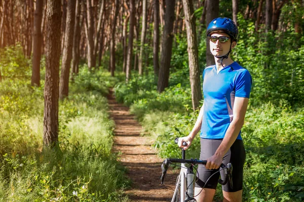 Jovem ciclista andando na floresta — Fotografia de Stock