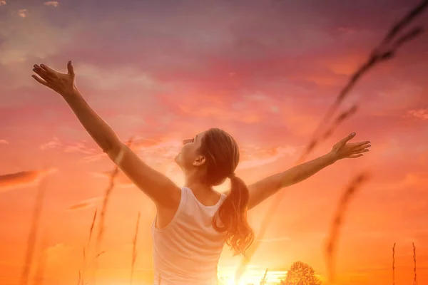 Mulher livre e feliz contra o céu por do sol — Fotografia de Stock