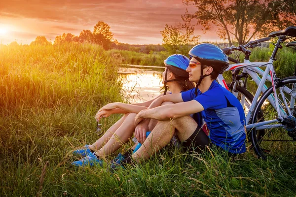 Coppia di ciclisti che si riposano vicino al fiume — Foto Stock