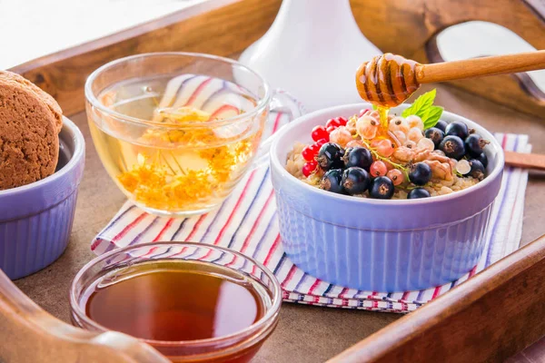 Вівсяна каша з ягодами, чаєм та печивом на сніданок — стокове фото