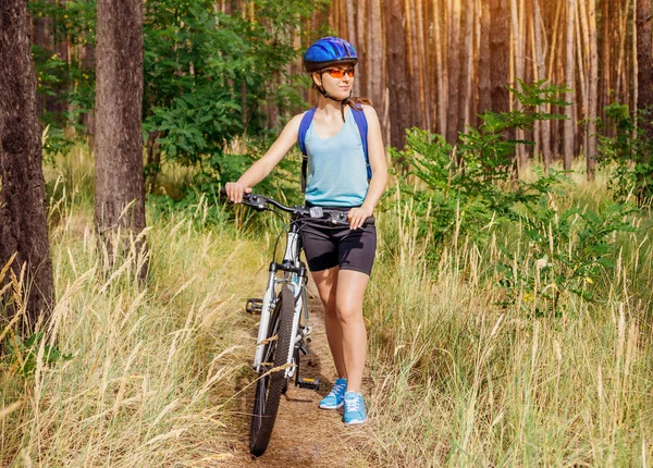 Jeune femme en vélo dans la forêt — Photo