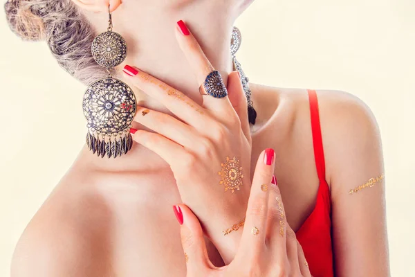 Tatuagem mehendi dourada nas mãos da mulher com manicure vermelho — Fotografia de Stock