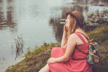Genç Gezgin kız nehir kenarında oturur