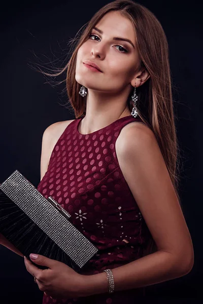 Beautiful woman with long hair holding a handbag — Stock Photo, Image