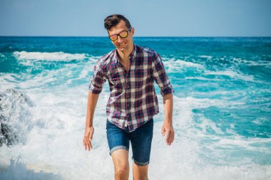 Genç adam kumsalda yürür