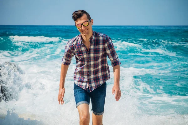 Genç adam kumsalda yürür