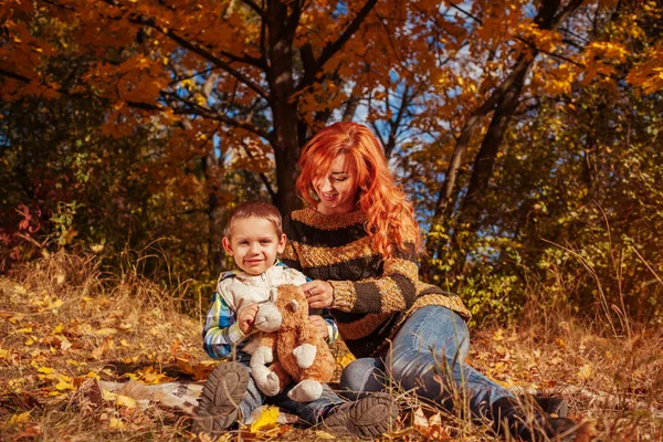 Szczęśliwą matką i jej synka, spacery i zabawy w lesie jesienią. — Zdjęcie stockowe