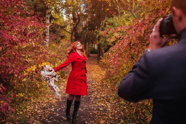 Homem tira uma foto de sua namorada na floresta de outono — Fotografia de Stock