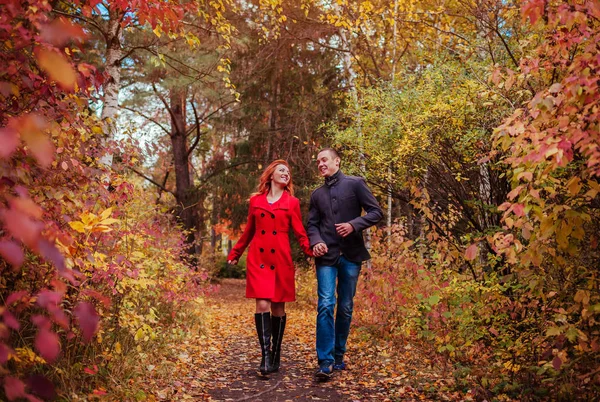 Giovane coppia corre nella foresta autunnale tra alberi colorati — Foto Stock