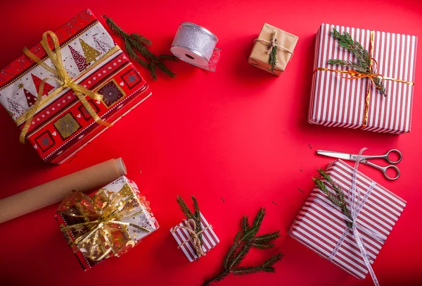 Caixas de presente decoradas com ramos de abeto no fundo vermelho . — Fotografia de Stock