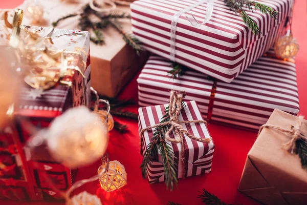 Caixas de presente decoradas com ramos de abeto no fundo vermelho . — Fotografia de Stock