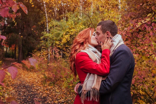 Молодая пара целуется в осеннем лесу среди — стоковое фото