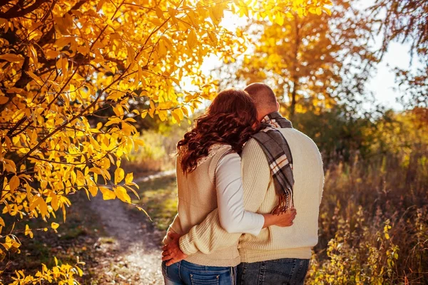 Couple d'âge moyen câlins dans la forêt d'automne parmi les arbres colorés — Photo