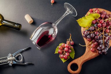 Bir bardak şarap bir şişe, tirbuşon ve üzüm ile