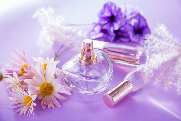 Пляшки парфумів з квітами — стокове фото