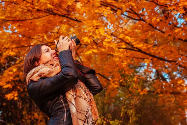 Jovem fotógrafo tira fotos da floresta de outono — Fotografia de Stock