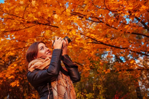 Jovem fotógrafo tira fotos da floresta de outono — Fotografia de Stock