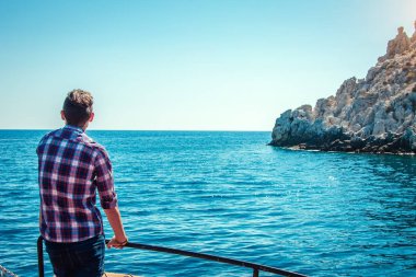 Genç adam bir ahşap yat deniz görünümü sahiptir