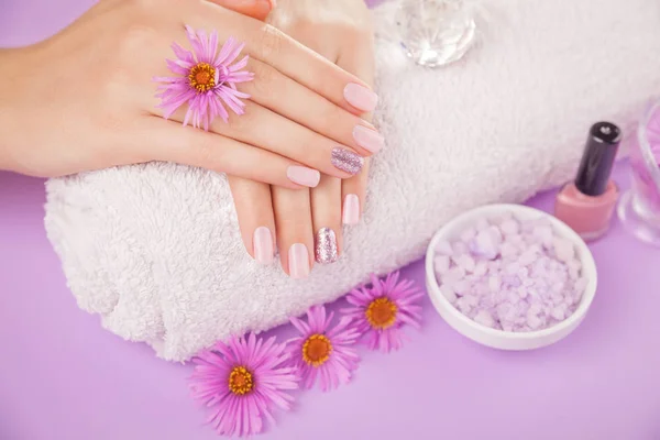 Schöne rosa und silberne Maniküre mit Blumen und Wellness-Essentials — Stockfoto