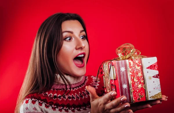 Photo studio d'une jeune femme en pull islandais tenant un coffret cadeau. Noel ou Nouvel An concept de célébration . — Photo