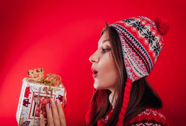 Estúdio de uma jovem em suéter islandês segurando uma caixa de presente. Conceito de celebração de Natal ou Ano Novo . — Fotografia de Stock